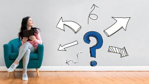 Sitzende Frau blickt nach rechts, rechts ein Fragezeichen von Richtungspfeilen umgeben